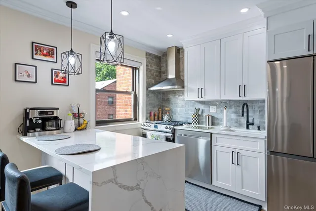 a kitchen with white cabinets stainless steel appliances and dining table
