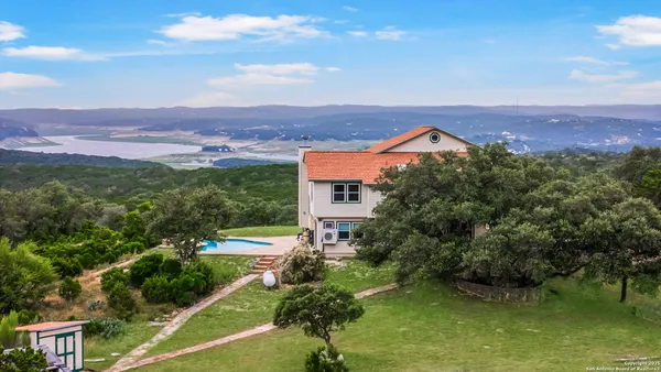 an aerial view of residential houses with outdoor space and a lake view