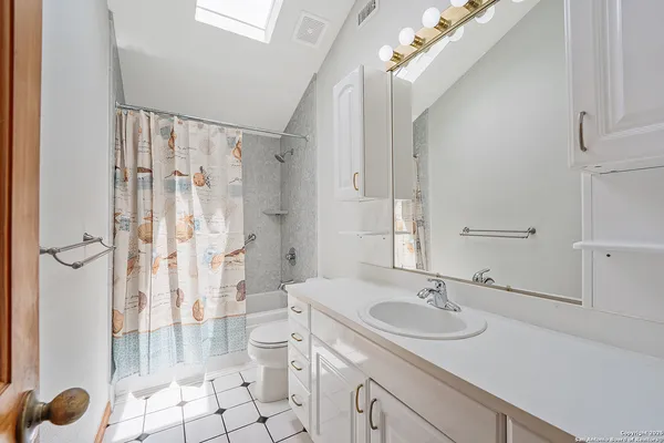 a bedroom with a bed a dresser next to a window