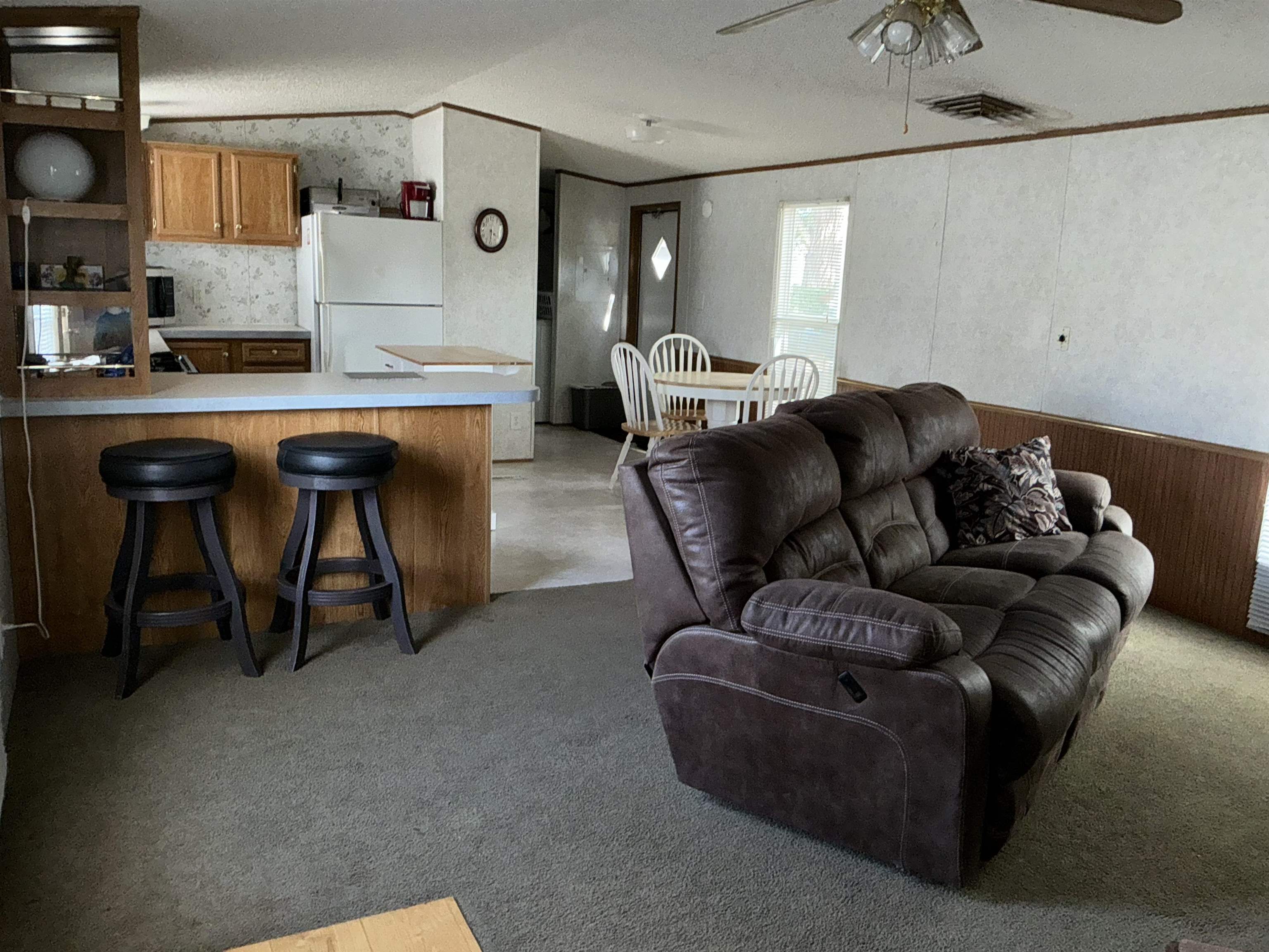 3268 E Road, Unit 90 Clifton, CO 81520 - Photo 5 of 19 a living room with furniture and a refrigerator