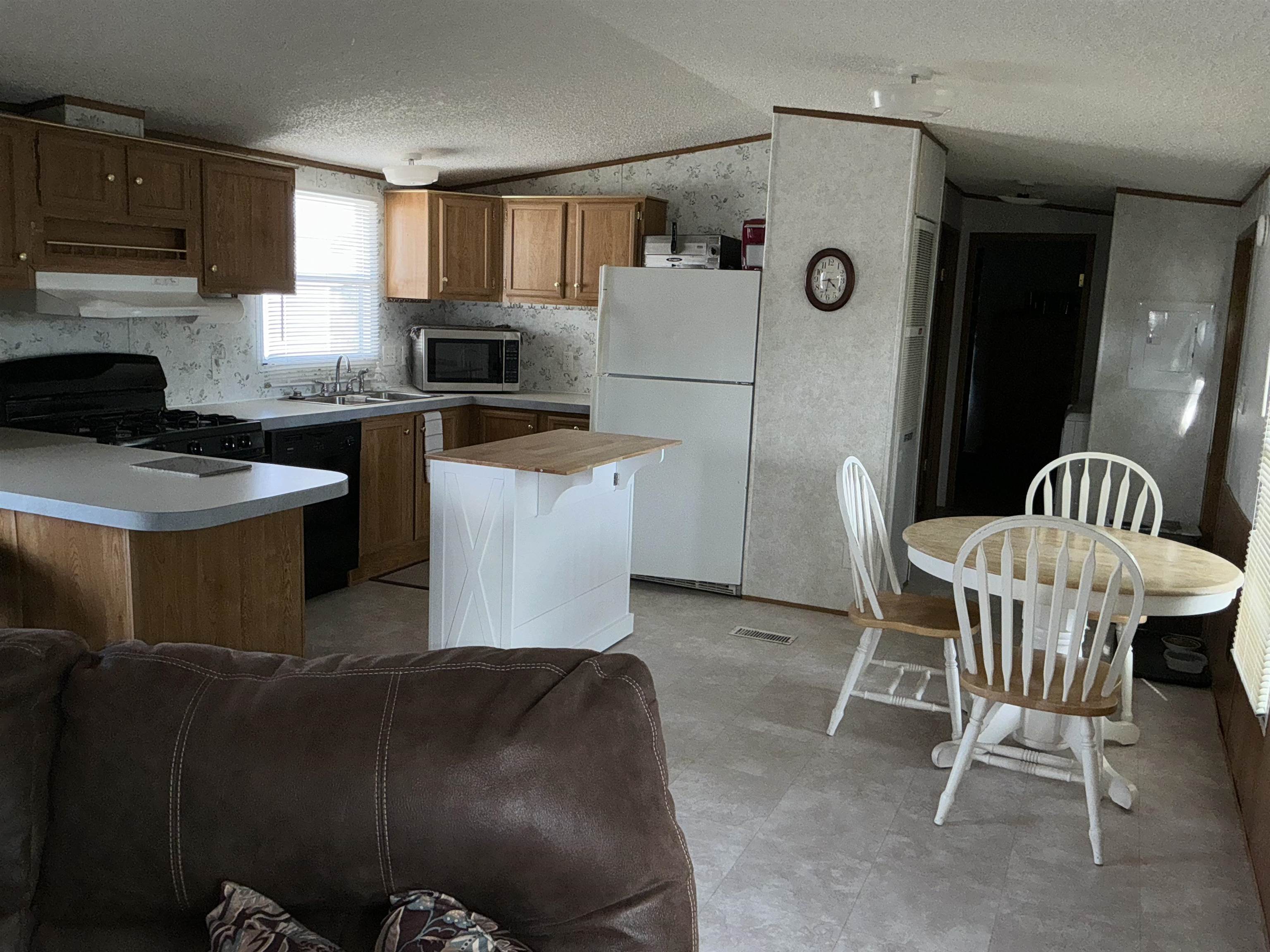 3268 E Road, Unit 90 Clifton, CO 81520 - Photo 9 of 19 a kitchen with a table chairs a refrigerator and a sink