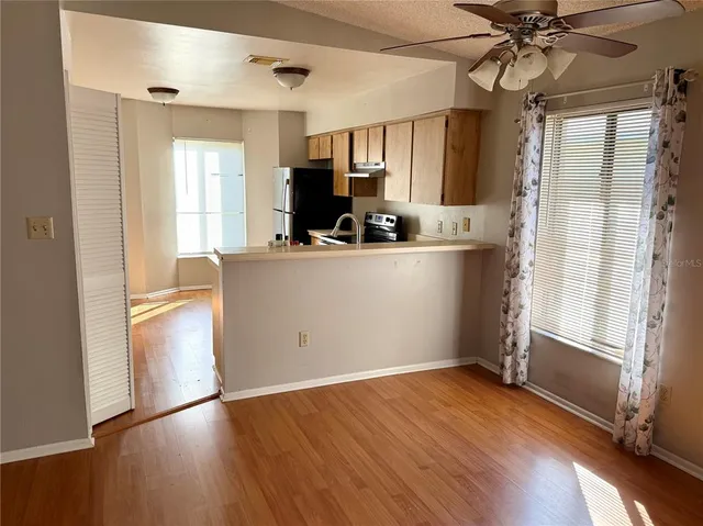 a view of kitchen with stainless steel appliances granite countertop a refrigerator oven a sink dishwasher and a refrigerator with wooden floor