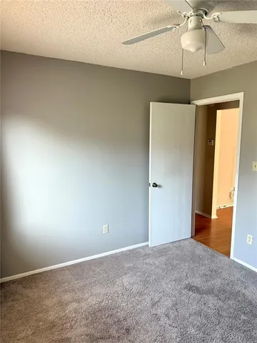an empty room with a ceiling fan and a window