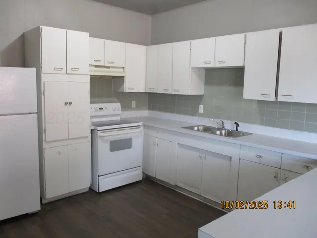 a kitchen with white cabinets and white appliances