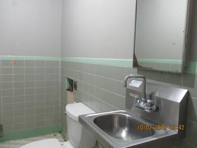 a bathroom with a sink a toilet and mirror