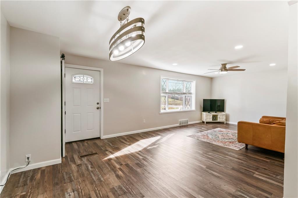 951 Shenango Road Beaver Falls, PA 15010 - Photo 4 of 42 an empty room with wooden floor mirror and windows