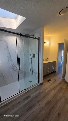 a view of a hallway with wooden floor and glass door