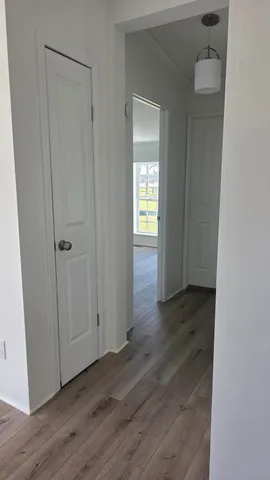 an empty room with wooden floor and closet area