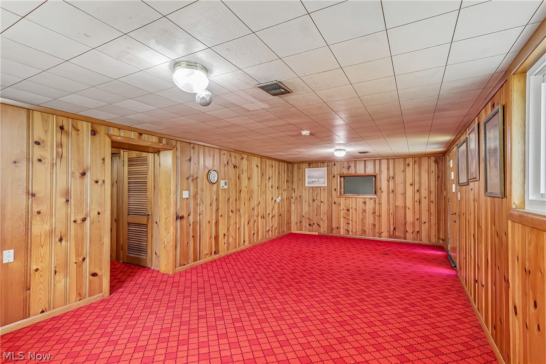 2060 6th Street Southwest Akron, OH 44314 - Photo 29 of 46 Lower level family room with knotty pine walls, closet space and carpet flooring