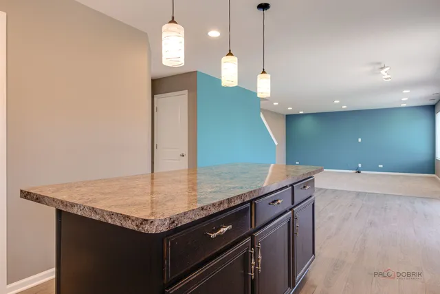 a kitchen with kitchen island a sink and wooden floor