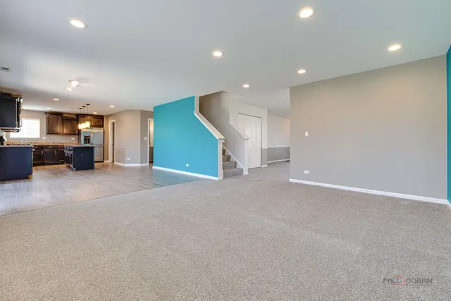 an empty room with furniture and a flat screen tv