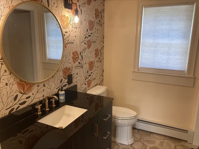 a bathroom with a toilet and a mirror