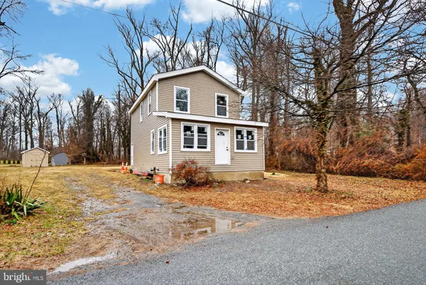 a white house that has a tree in front of it