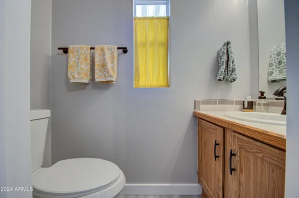 a bathroom with a sink vanity mirror and toilet