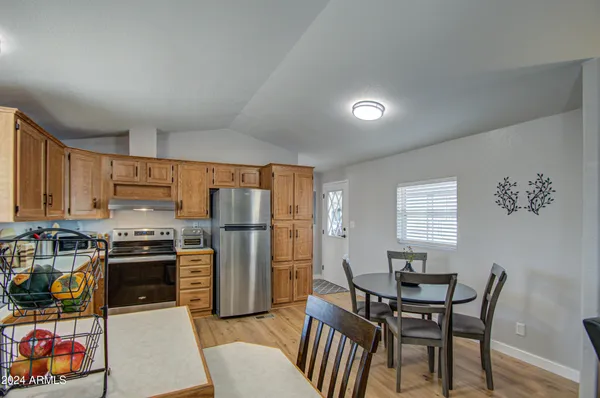 a kitchen with stainless steel appliances a stove a refrigerator a dining table and chairs