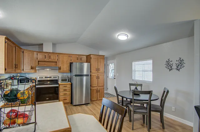 a kitchen with stainless steel appliances a stove a refrigerator a dining table and chairs