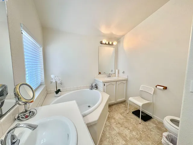 a bathroom with a granite countertop sink toilet and mirror