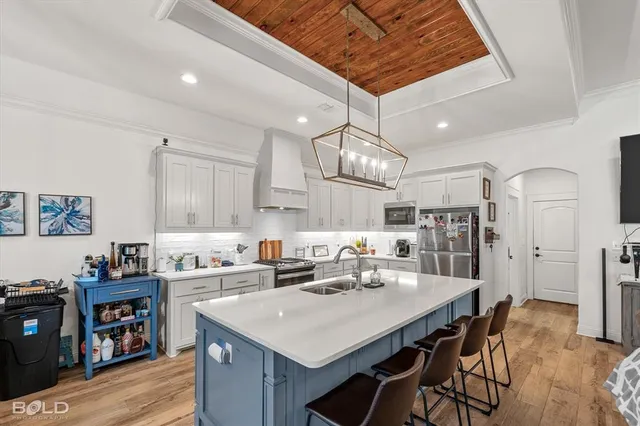 a kitchen with stainless steel appliances a table chairs refrigerator and cabinets