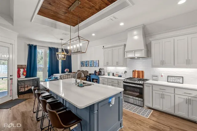 a kitchen that has a lot of cabinets in it and wooden floors