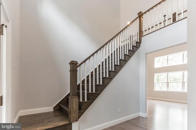 a view of staircase with wooden floor and white walls