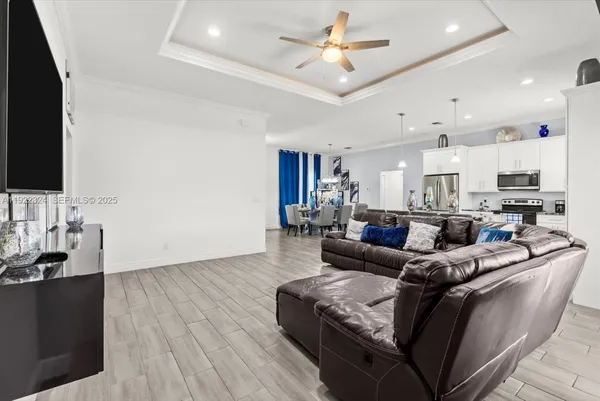 a kitchen with kitchen island granite countertop a table chairs microwave and refrigerator