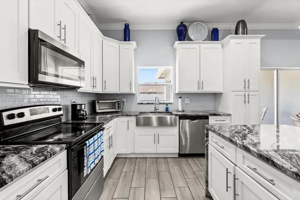 a kitchen with stainless steel appliances kitchen island granite countertop a sink and a stove