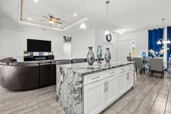 a kitchen with stainless steel appliances granite countertop a refrigerator stove and white cabinets