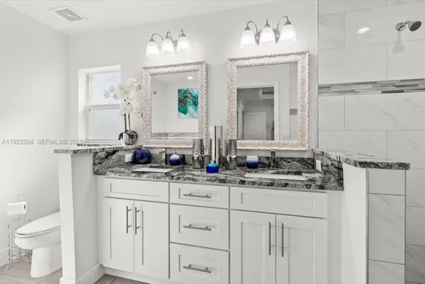 a bathroom with double vanity and two mirror