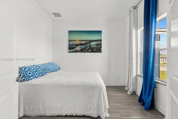 a bedroom with a bed and a painting on the wall