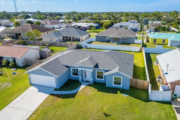 an aerial view of a house with swimming pool and ocean view