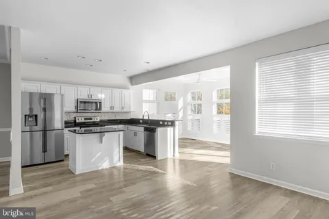 a kitchen with stainless steel appliances granite countertop a refrigerator and a stove top oven