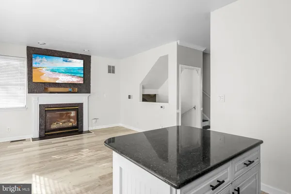 a living room with stainless steel appliances furniture a fireplace and a flat screen tv