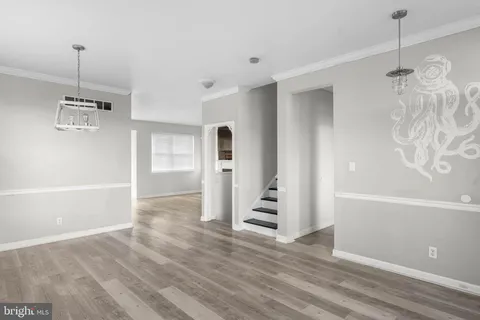 a view of empty room with wooden floor and ceiling fan