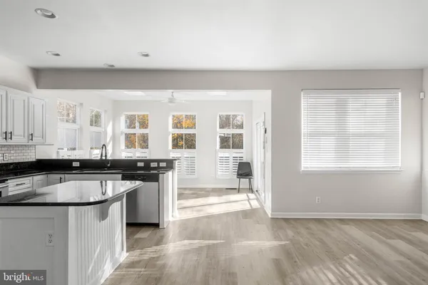 a kitchen with granite countertop a stove a sink and a refrigerator