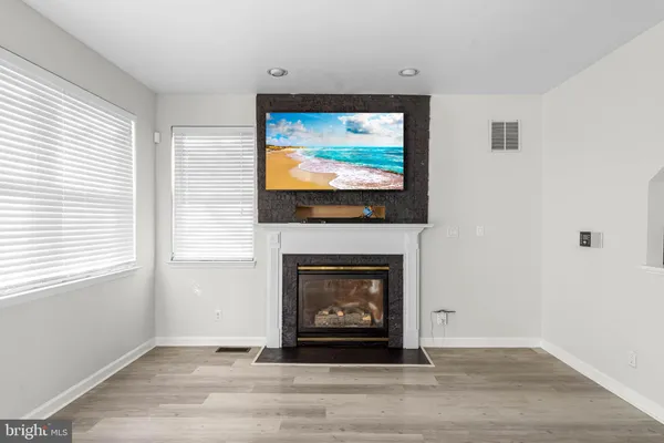 a living room with a fireplace a flat screen tv and a window