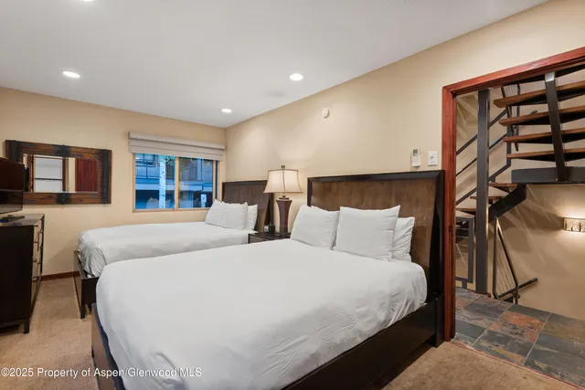 a bed room with two beds and a night stand