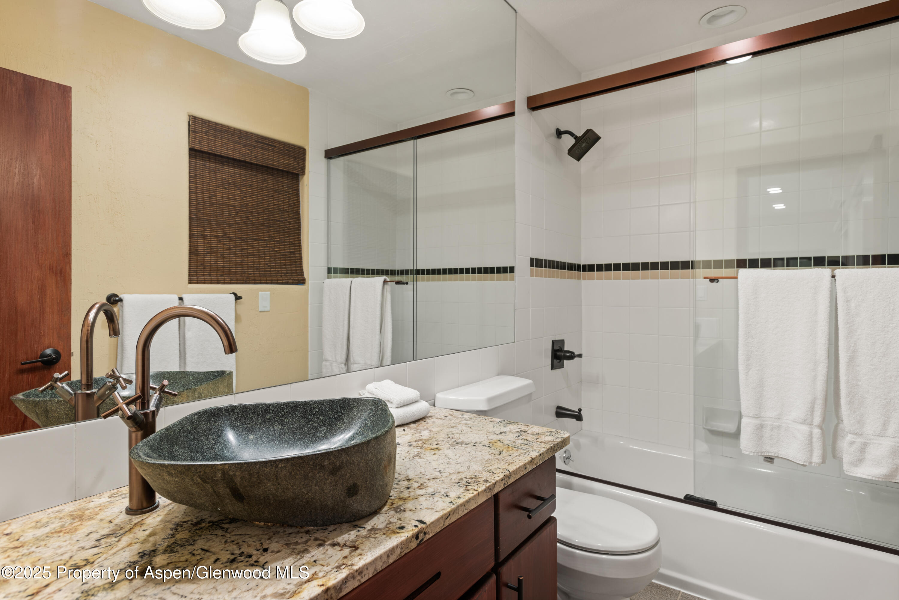 650 South Monarch Street, Unit 4 Aspen, CO 81611 - Photo 27 of 37 a bathroom with a granite countertop sink toilet a mirror and shower