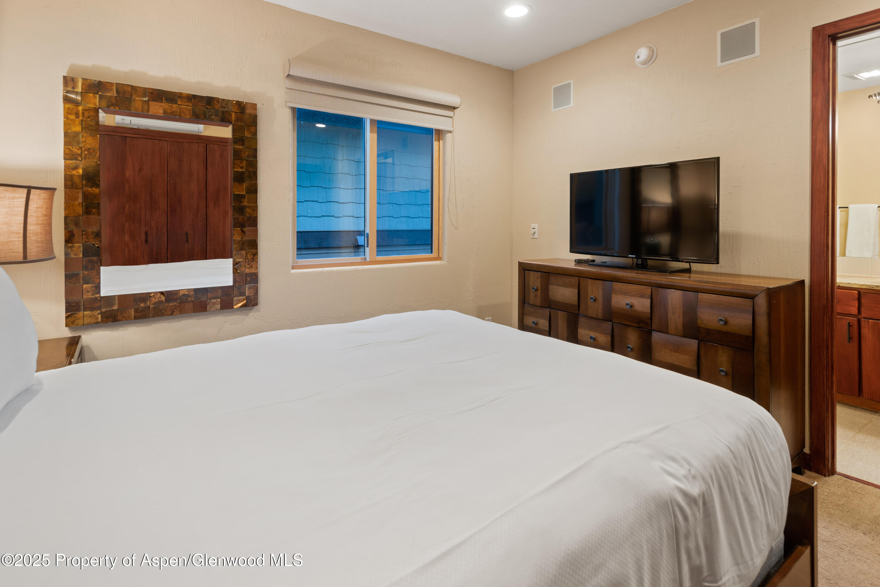 650 South Monarch Street, Unit 4 Aspen, CO 81611 - Photo 29 of 37 a bedroom with a bed and a flat screen tv