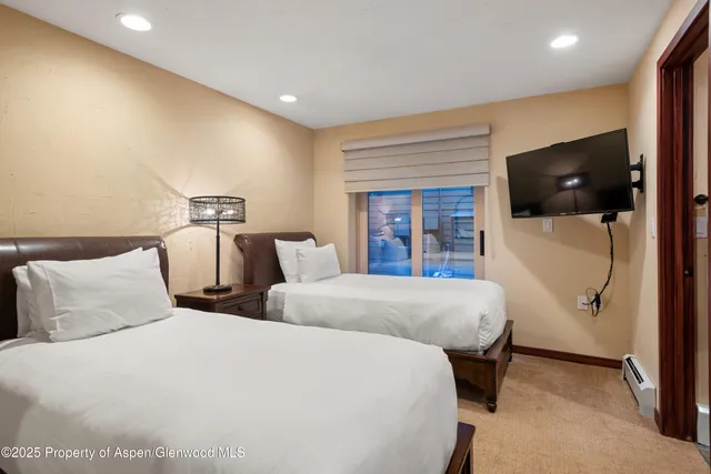 a bed room with two bed and a television