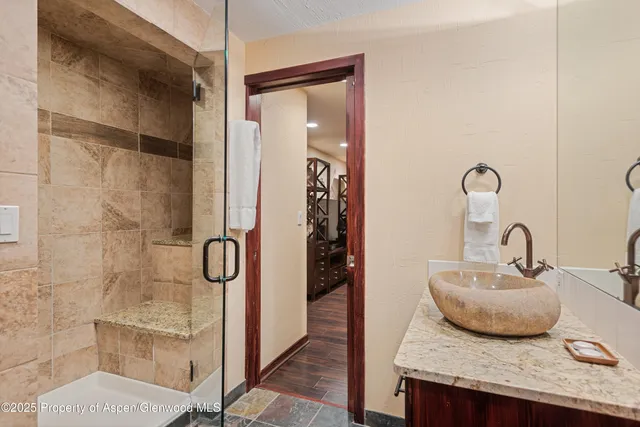 a bathroom with a granite countertop sink and a mirror
