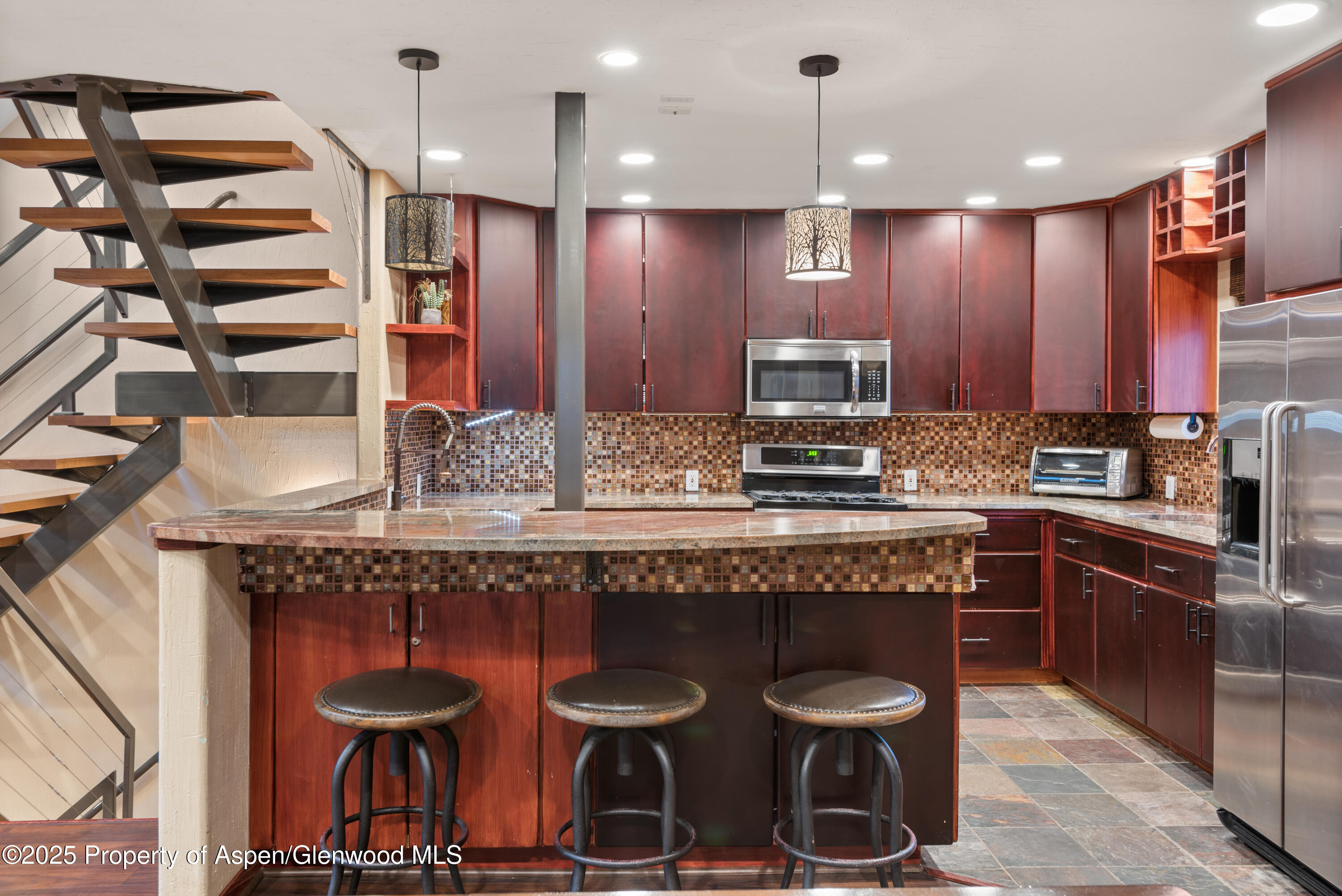 650 South Monarch Street, Unit 4 Aspen, CO 81611 - Photo 7 of 37 a kitchen with kitchen island granite countertop wooden cabinets and a refrigerator