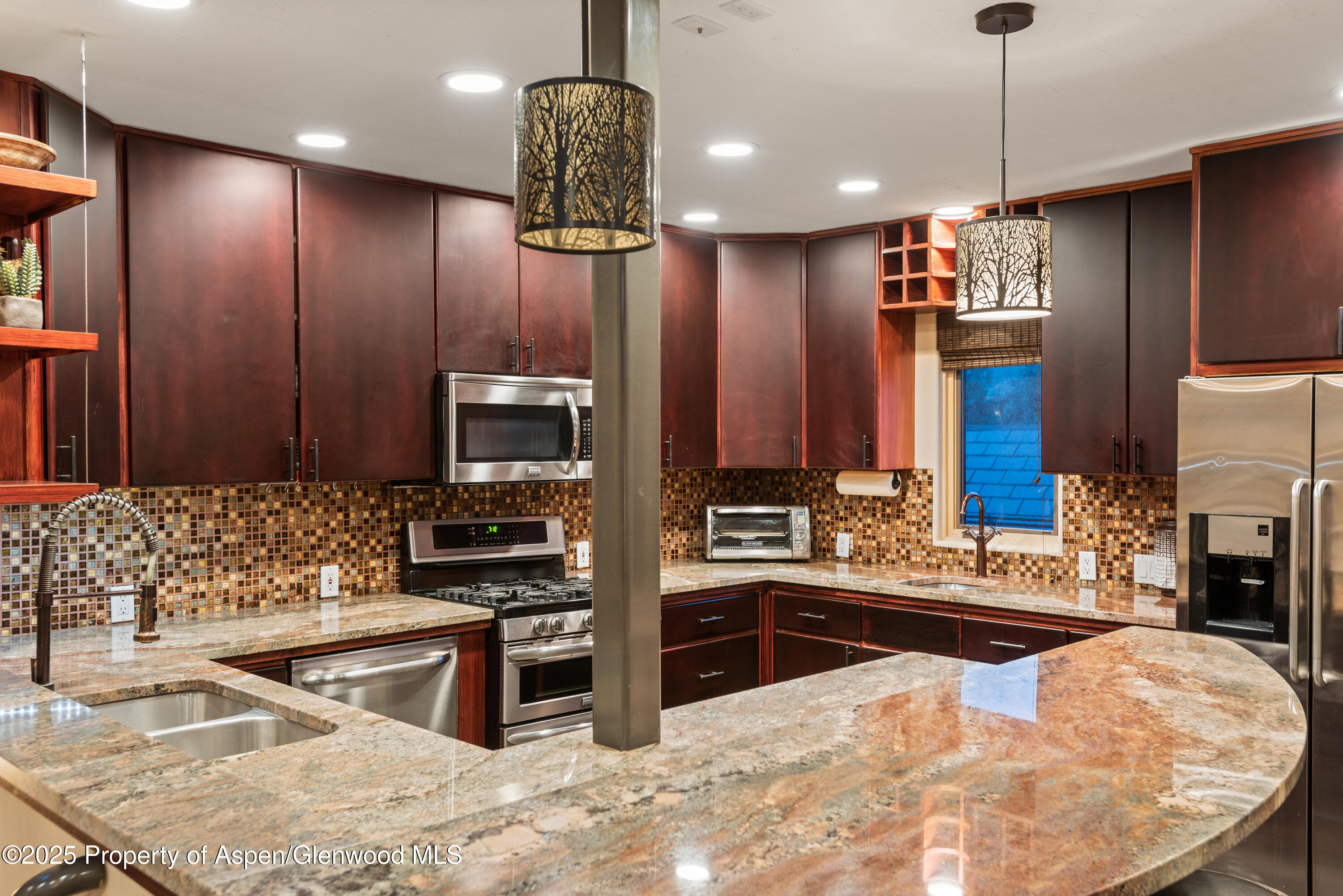 650 South Monarch Street, Unit 4 Aspen, CO 81611 - Photo 9 of 37 a kitchen with stainless steel appliances kitchen island granite countertop a stove a sink and a microwave