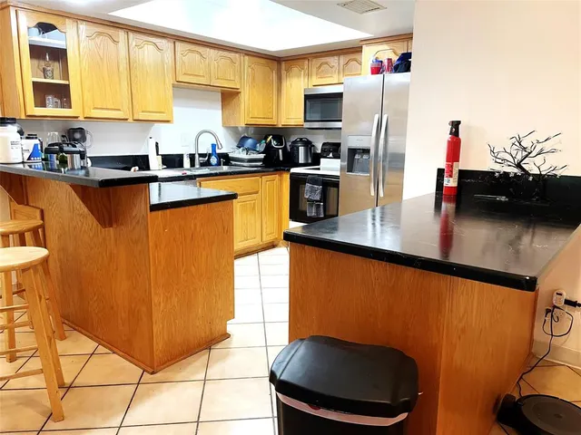 a kitchen with stainless steel appliances granite countertop a sink refrigerator and microwave