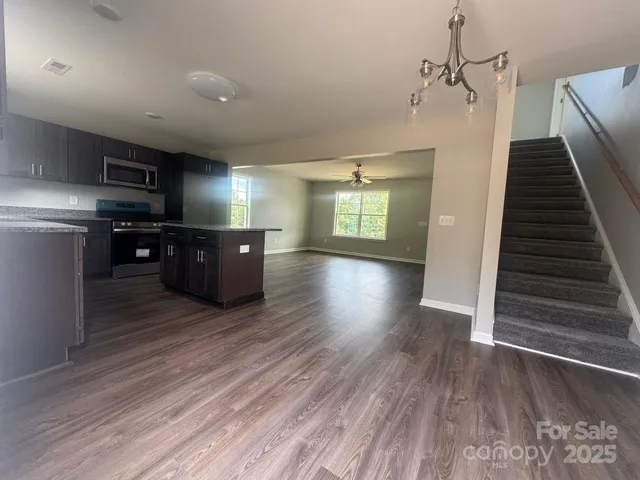 a view of a livingroom with furniture wooden floor and staircase