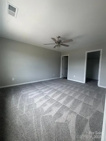 a view of an empty room with a chandelier fan