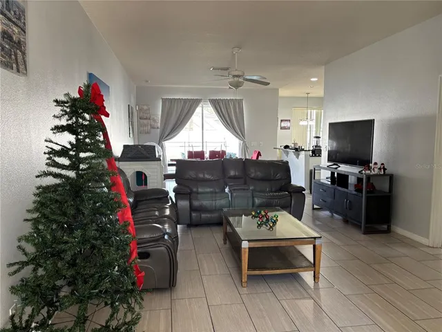 a living room with furniture a flat screen tv and a potted plant