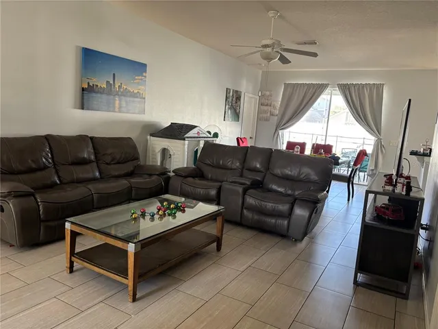 a living room with furniture a flat screen tv and a window
