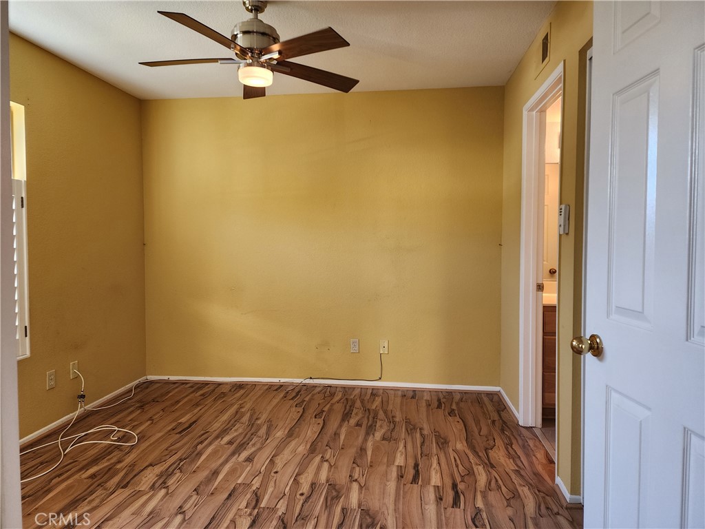 7350 Greenhaven Avenue, Unit 59 Rancho Cucamonga, CA 91730 - Photo 9 of 20 a view of a room with wooden floor and a ceiling fan