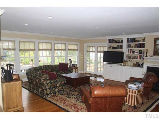 418 Yarmouth Road Raleigh, NC 27608 - Photo 8 of 25 a living room with furniture a flat screen tv and a floor to ceiling window