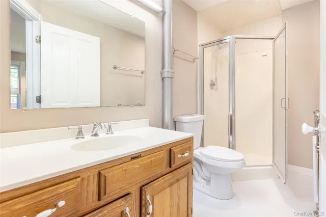 a bathroom with a sink a toilet a mirror and shower